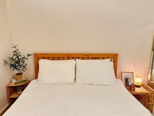 a bed with white sheets and a wooden headboard at 갓성비 암사역 도보 Yes24live 암사종합시장 한강공원 KSPO 2룸 2퀸 침대 in Seoul