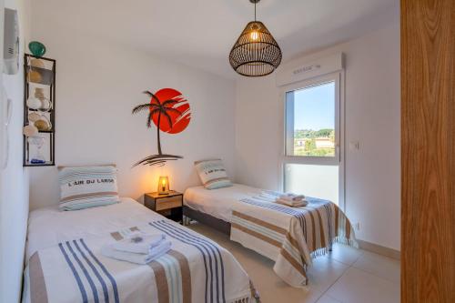 une chambre avec deux lits et une fenêtre dans l'établissement Appartement Sainte-Maxime - Welkeys, à Sainte-Maxime