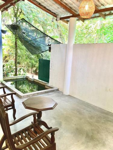 a patio with two rocking chairs and a pond at Seashore Mirissa in Mirissa