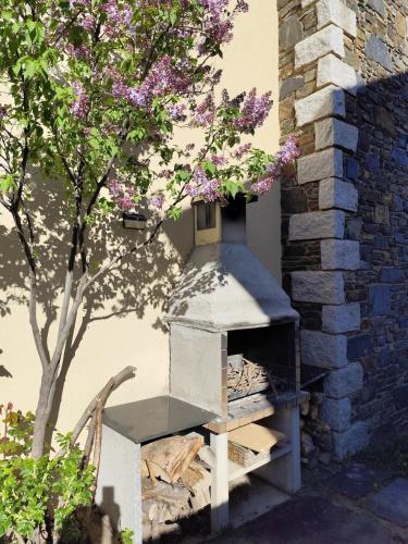 a bird house sitting next to a tree with purple flowers at L'avet blau in Sainte-Léocadie