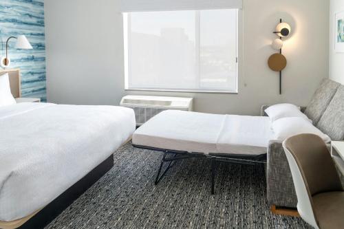 a hotel room with two beds and a couch at TownePlace Suites by Marriott Detroit Taylor in Taylor