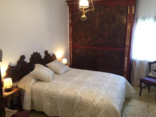 a bedroom with a large bed with a wooden headboard at Casa Justo in Apiés