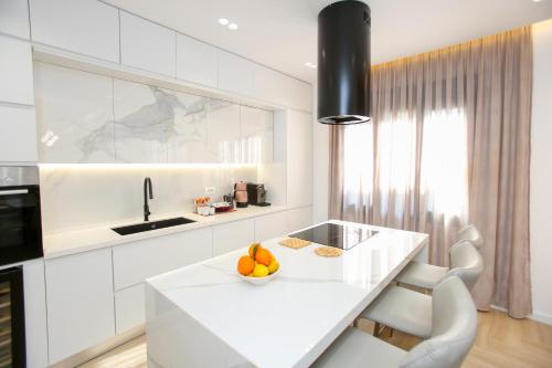 a white kitchen with a counter and a bowl of fruit at Villa Meminaj in Vlorë