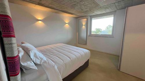 a bedroom with a bed with a window and lights at Vale das Estrelas in São Teotónio