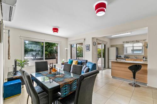 a dining room and living room with a table and chairs at A Piece of Africa in Mandria by VICHY Holidays in Paphos