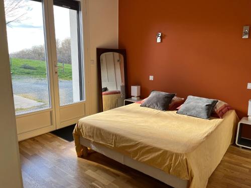 une chambre avec un lit et une grande fenêtre dans l'établissement La Maison de Mendigou, à Montredon