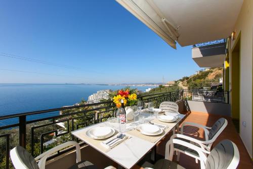 a table on a balcony with a view of the ocean at Villa Meminaj in Vlorë