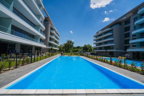 a swimming pool in front of a building at MyFlat Wave Beach Apartments in Siófok
