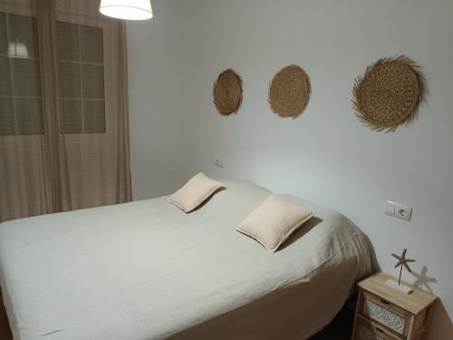 a bedroom with a white bed with two pillows on it at Palomares in Cuevas del Almanzora