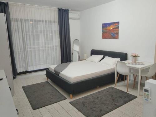 a bedroom with a bed and a table and a desk at Desilva Residences - Loft Club in Mamaia