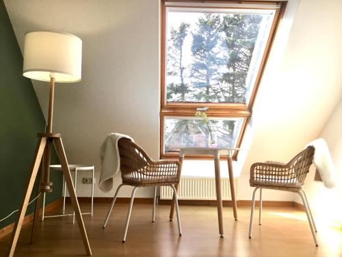 two chairs and a lamp in a room with a window at Seute Deern- Görtz in Fehmarn