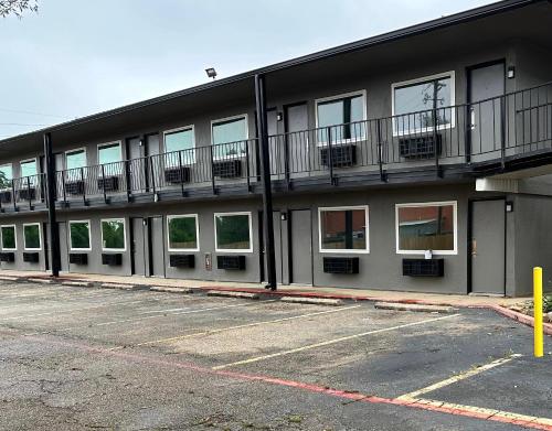 an apartment building with balconies and a parking lot at Studio City Suites, a Travelodge by Wyndham in Texarkana - Texas