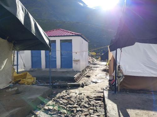 a building with blue doors on the side of a mountain at Himalayan Hill Camps By StayApart in Kedārnāth