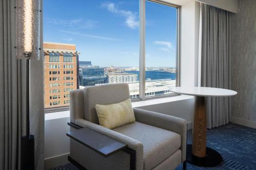 a living room with a chair and a large window at Renaissance Boston Seaport District in Boston