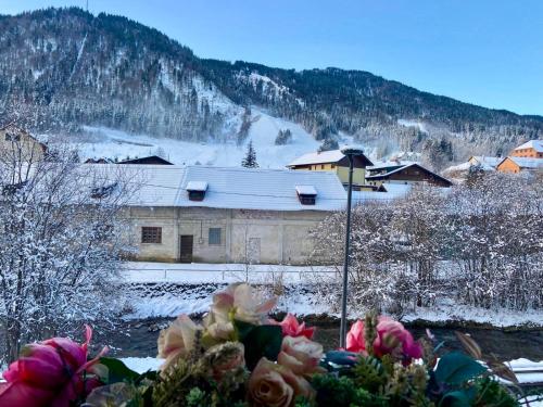 a house with a snow covered roof in front at Appartamento FedElia a Tarvisio vicino al centro in Tarvisio