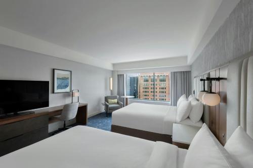 a hotel room with two beds and a flat screen tv at Renaissance Boston Seaport District in Boston