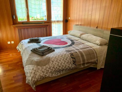 a bedroom with a bed with a blanket on it at Appartamento FedElia a Tarvisio vicino al centro in Tarvisio