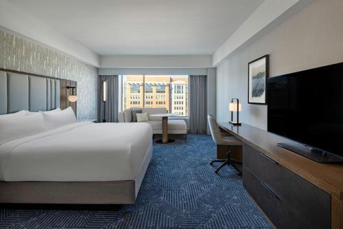 a hotel room with a bed and a flat screen tv at Renaissance Boston Seaport District in Boston