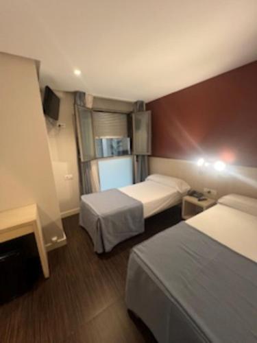 a hotel room with two beds and a television at El Globo in Valencia