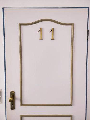 a white door with the number on it at FeWo Nesthäkchen-Erholung in Historischer Villa an der Nordsee in Dornum