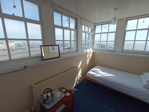 a room with windows and a bed and a mirror at Royal Norfolk & Suffolk Yacht Club in Lowestoft