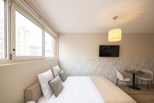 une chambre avec un lit, une fenêtre et une table dans l'établissement Studio calme proche de Paris 19 - V, à Le Pré-Saint-Gervais