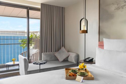a hotel room with a bed with a tray of food at Novotel Goa Panjim in Panaji