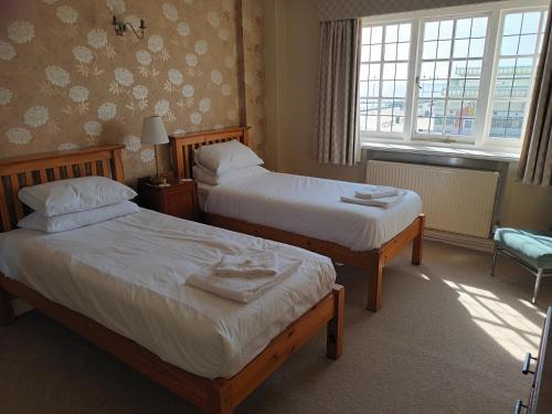 a hotel room with two beds and a window at Royal Norfolk & Suffolk Yacht Club in Lowestoft