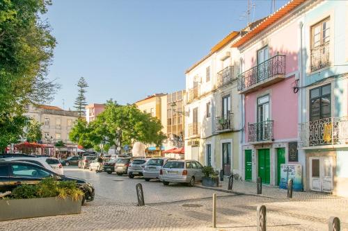 a city street with parked cars and buildings at Hooked on Troino in Setúbal
