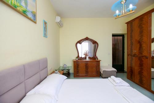 a bedroom with a bed and a dresser and a mirror at Villa Meminaj in Vlorë