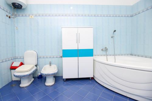a bathroom with a tub and a toilet and a sink at Villa Meminaj in Vlorë