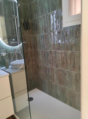 une douche avec une porte vitrée dans une salle de bain dans l'établissement CHARMANT STUDIO AVEC TERRASSE et VUE MER EXCEPTIONNELLE, à Sainte-Maxime