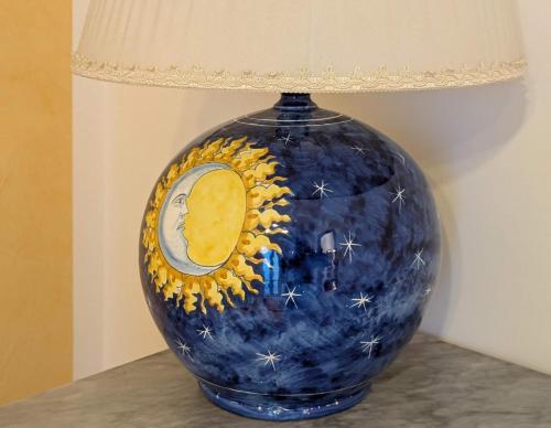 a blue vase sitting on a table with a lamp at Villa Girasole Luxury Amalfi Coast in Minori