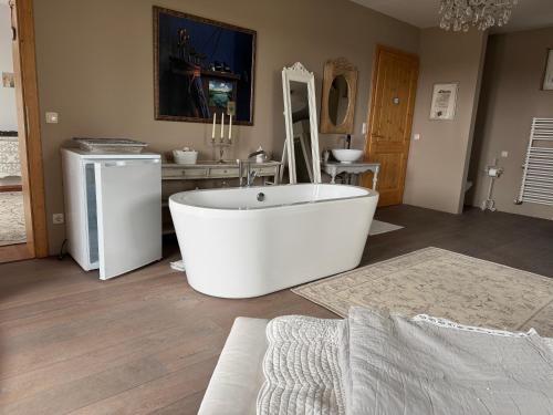a bathroom with a white tub and a sink at Spa&Golf-Suite Velden in Velden am Wörthersee