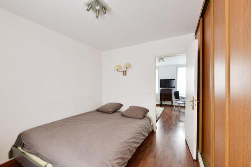 une chambre avec un lit dans une pièce blanche dans l'établissement The Cosy Cocon Close to Eiffel Tower & Invalides, à Paris