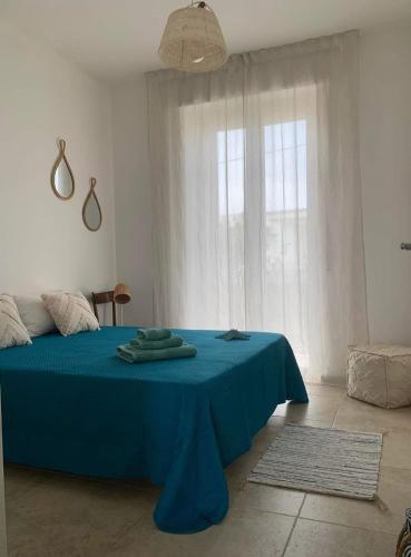 a bedroom with a blue table in front of a window at Casa Ambra in Specchiolla 
