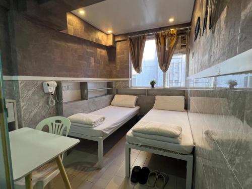 una stanza con due letti e un tavolo di 168 Youth Hostel a Hong Kong