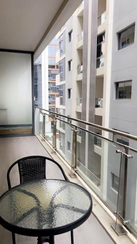 a table and a chair on a balcony at Trendy Stay Apartments in Muscat