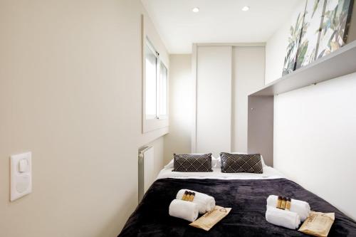 une chambre avec un lit avec deux oreillers dessus dans l'établissement La Terrazza - Palais des festivals et Croisettes, à Cannes