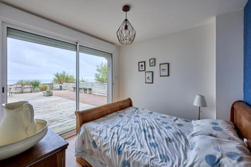 une chambre avec un lit et une grande fenêtre dans l'établissement La Villa des Marées - Front de mer, à Asnelles