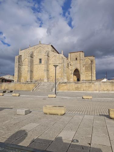 un antiguo edificio de piedra con un gran edificio en Hostal las Cantigas, en Villalcázar de Sirga