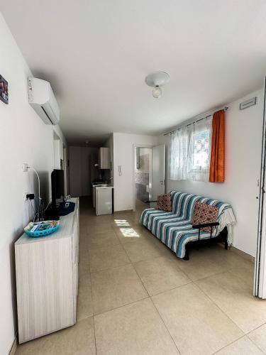 un salon avec un canapé et une télévision dans l'établissement APPARTAMENTO 5 POSTI - Puglia - Marina di Pescoluse, à Marina di Pescoluse