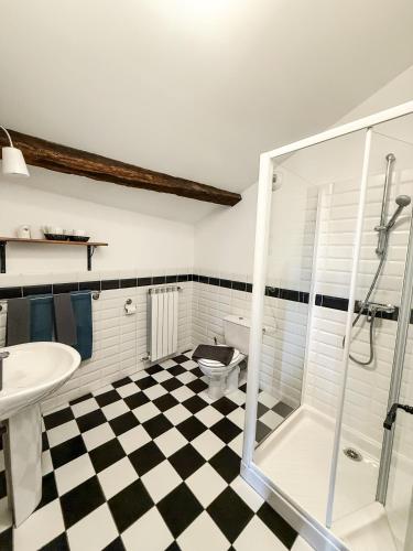 La salle de bains est pourvue d'un sol en damier noir et blanc. dans l'établissement Le Saint-Laurans, à Aurignac