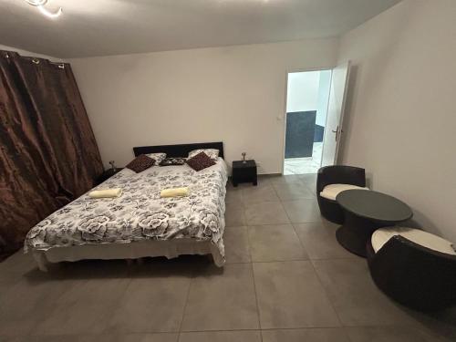 a bedroom with a bed and a table and chairs at Belle Maison dans le Beaujolais in Gleizé