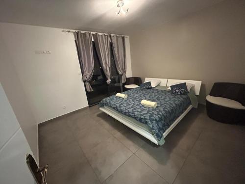 a bedroom with a bed and a chair in it at Belle Maison dans le Beaujolais in Gleizé