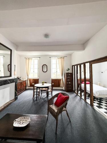 a bedroom with a bed and a table with a red pillow at Le Saint-Laurans in Aurignac