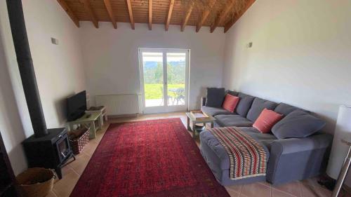 a living room with a blue couch and a red rug at Vale das Estrelas in São Teotónio