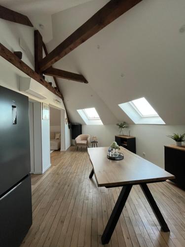 - un salon avec une table et quelques lucarnes dans l'établissement Appartement type T2 Il Giardino Sospeso, au Creusot