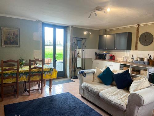 un salon avec un canapé et une cuisine avec une table dans l'établissement Pear gîte set in beautiful private surroundings, à Millac