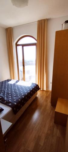 a bedroom with a bed and a large window at Vineyard Spa Resort 2-Room Apartement in Kableshkovo